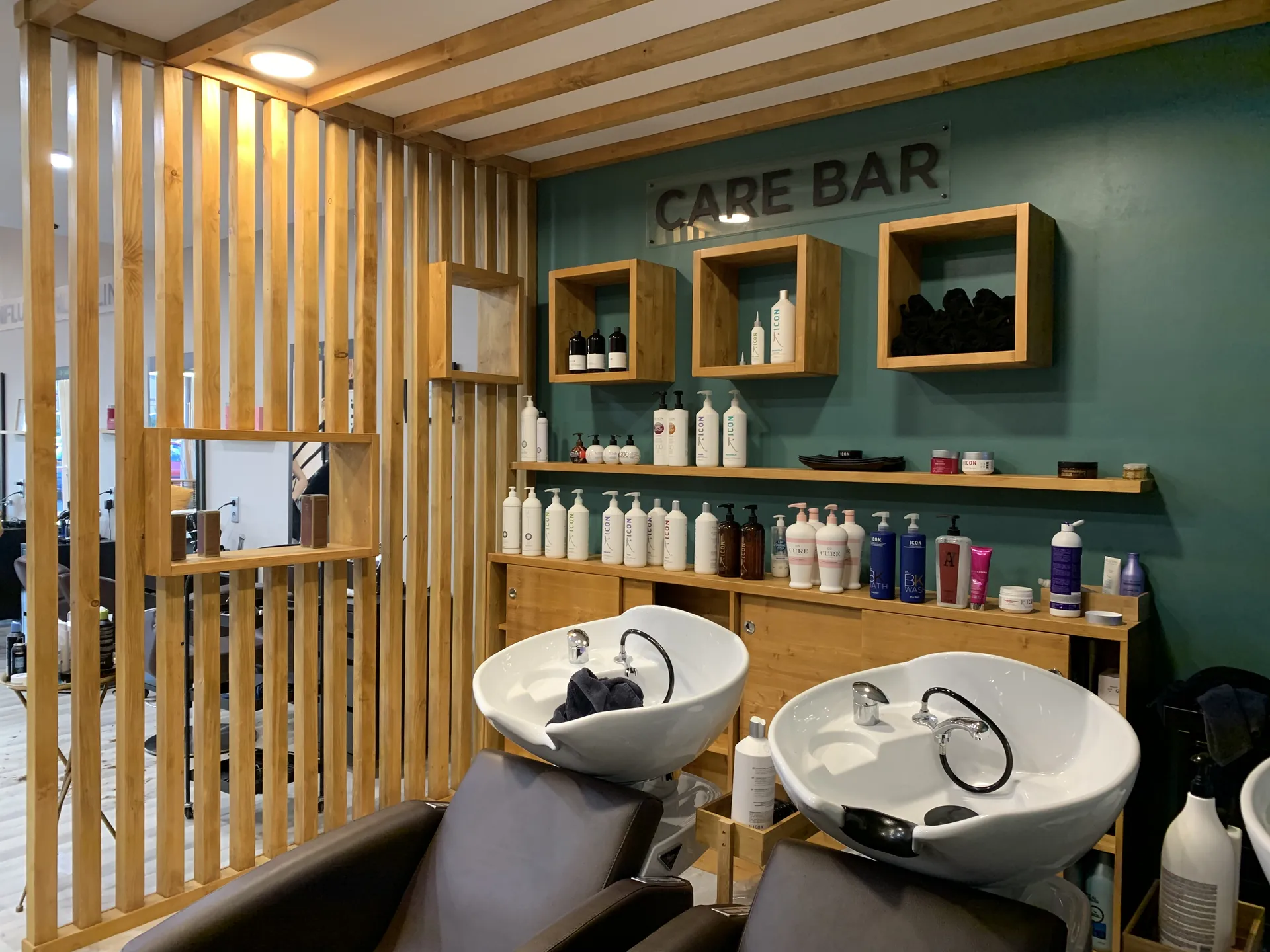 Espace bacs d'un salon de coiffure � La Crau, claustra en bois et mur vert